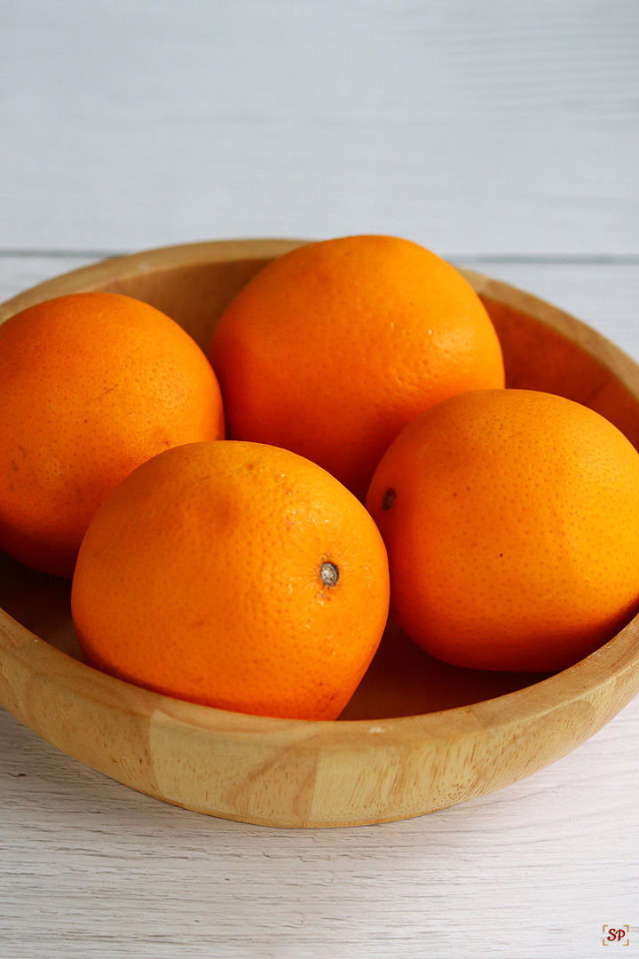 oranges placed in a wooden bowl