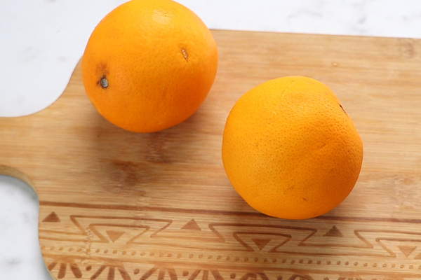 take 2 oranges in a chopping board