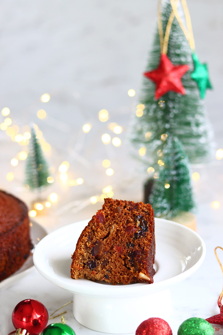 plum cake on a plate with christmas tree on the background
